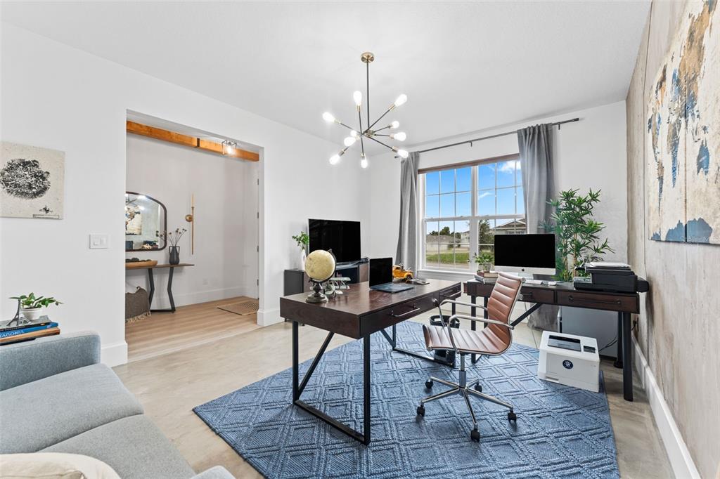 A home office features a dark wood desk, a blue area rug, and a globe — 2640 HILLTOP LOOP, APOPKA, FL