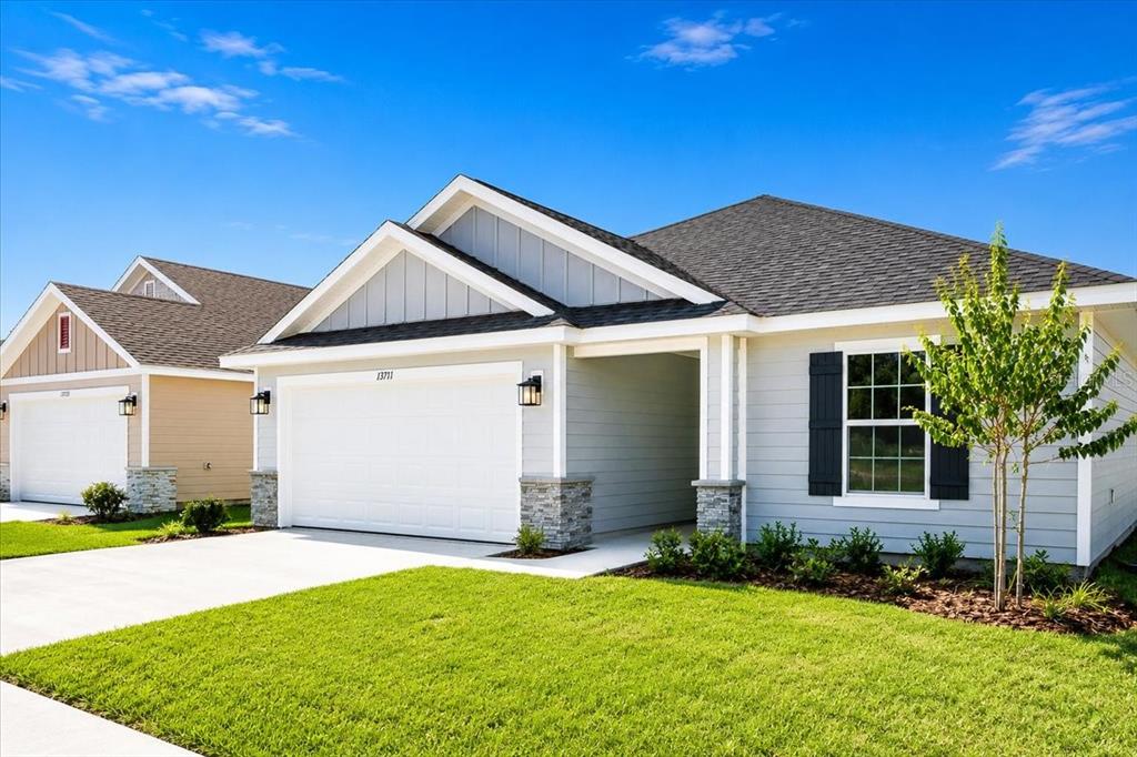 A light gray single-story house with a two-car garage and a front lawn — 13711 NW 150TH CIRCLE, ALACHUA, FL