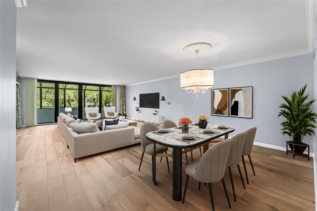 A dining area and living room with light wood floors, a marble table, and floor-to-ceiling windows — 6265 MIDNIGHT PASS ROAD UNIT 102, SARASOTA, FL