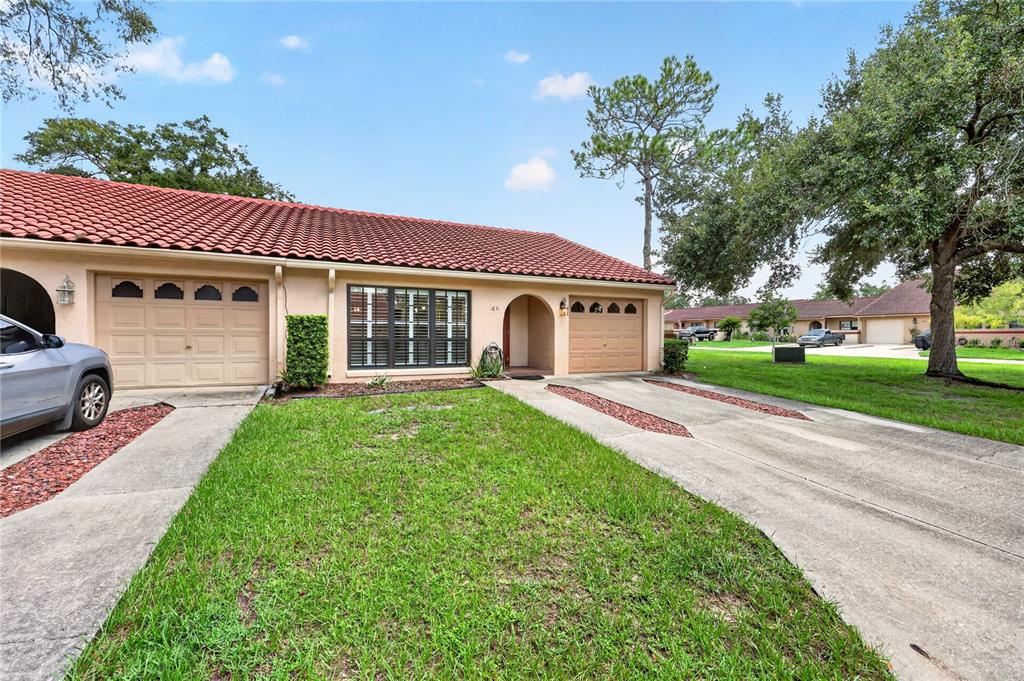 A single-story duplex with a red tile roof, two garage doors, and a front lawn — 1831 SW 35TH AVENUE, OCALA, FL