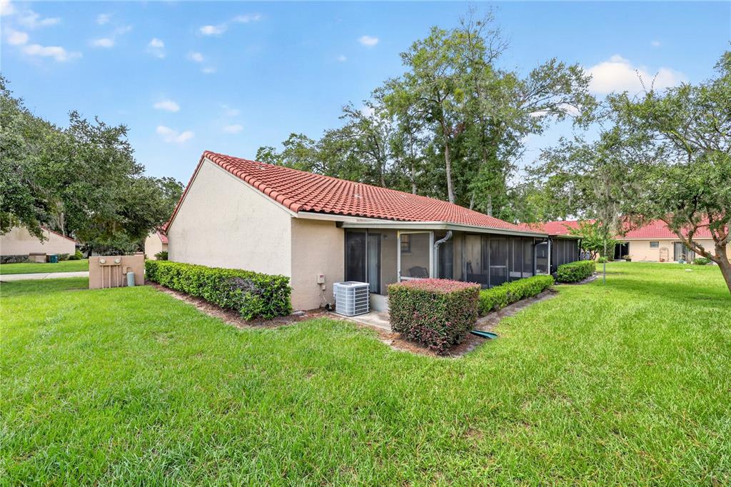 The exterior of a beige stucco house with a red tile roof and screened patio — 1831 SW 35TH AVENUE, OCALA, FL