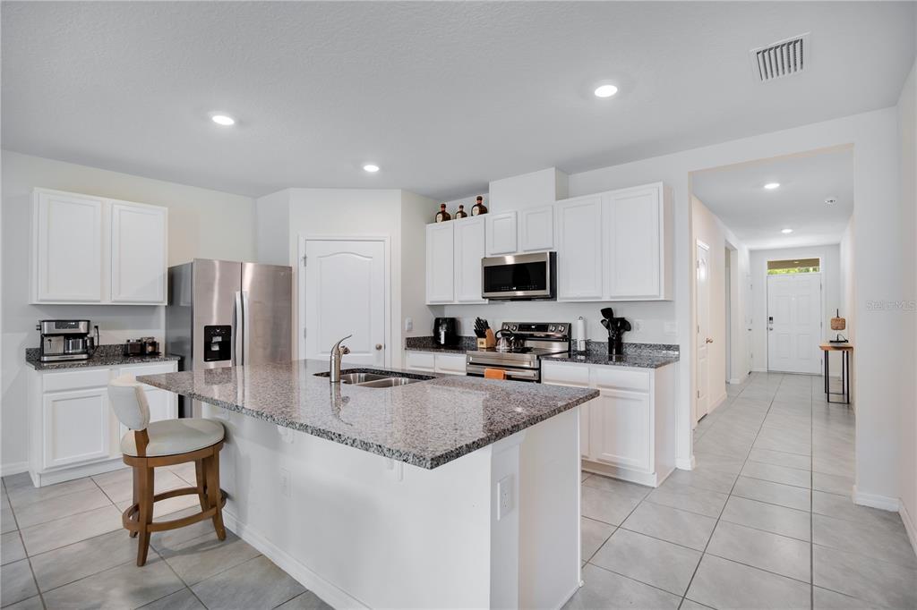 A single-story house with a beige stucco exterior, a two-car garage, and a concrete driveway — 3768 BOTANICAL WAY, SANFORD, FL