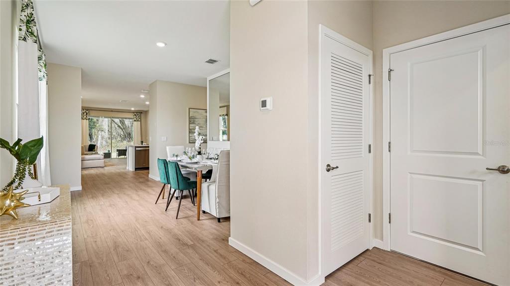 An interior view shows a dining area with wood-look flooring and a white louvered door — 3999 NW 44TH CIRCLE, OCALA, FL