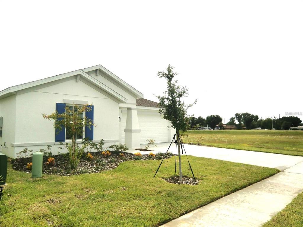 A single-story white house with blue shutters and a two-car garage — 172 INMAN BOULEVARD, WINTER HAVEN, FL