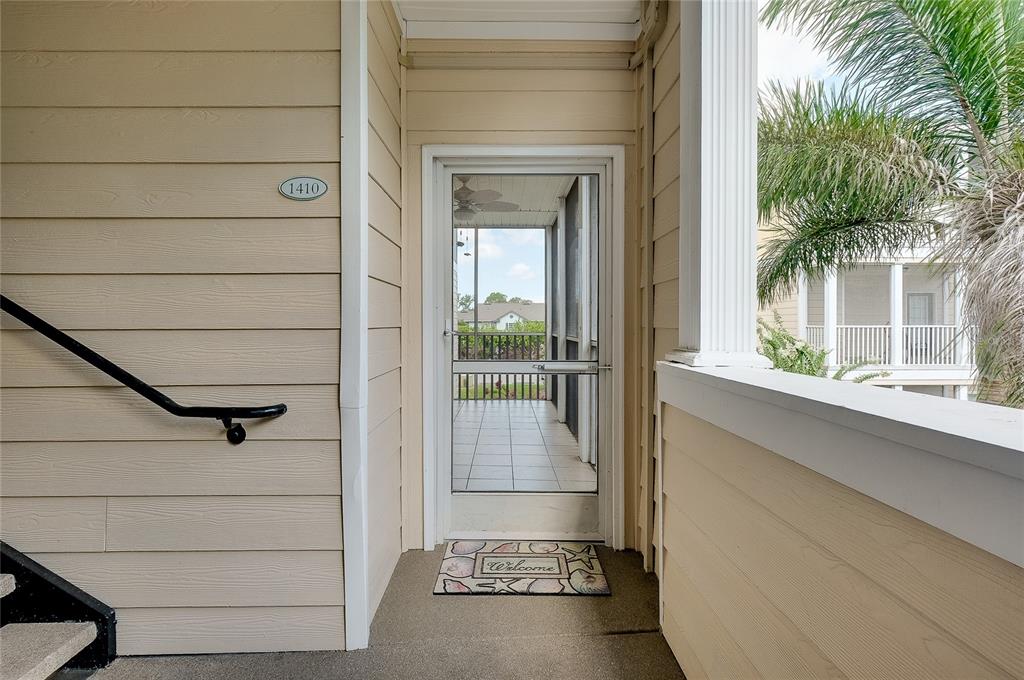 A screened-in balcony with tiled flooring overlooks a parking area and neighboring apartment buildings — 4802 51ST STREET W UNIT 1410, BRADENTON, FL