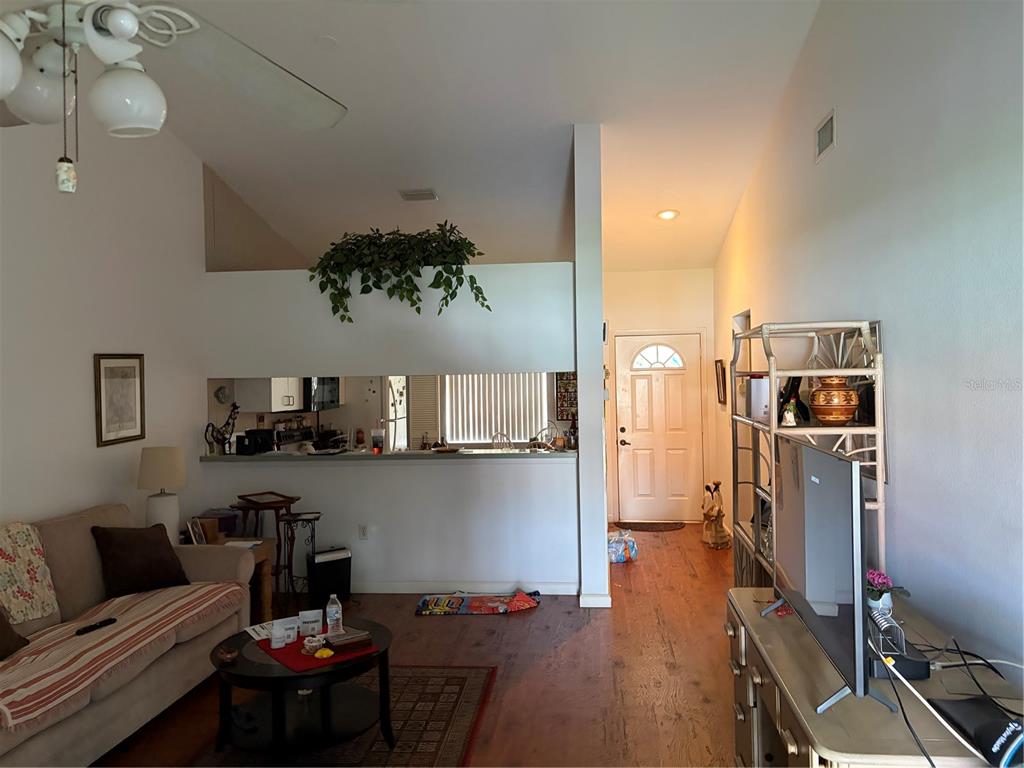 A living room with a sofa, coffee table, and an open kitchen pass-through window — 4268 MADEIRA COURT UNIT 3324, SARASOTA, FL