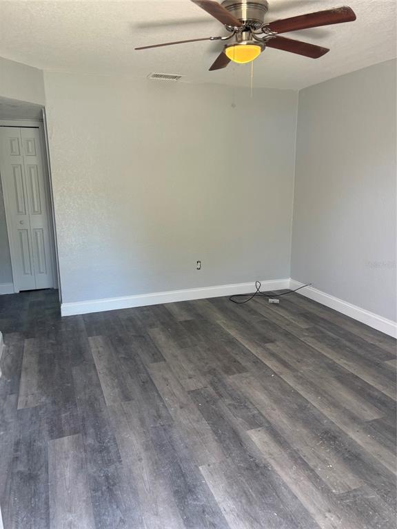 An empty room features gray walls, wood-look laminate flooring, a ceiling fan, and a closet — 4321 LAKE LAWNE AVENUE, ORLANDO, FL