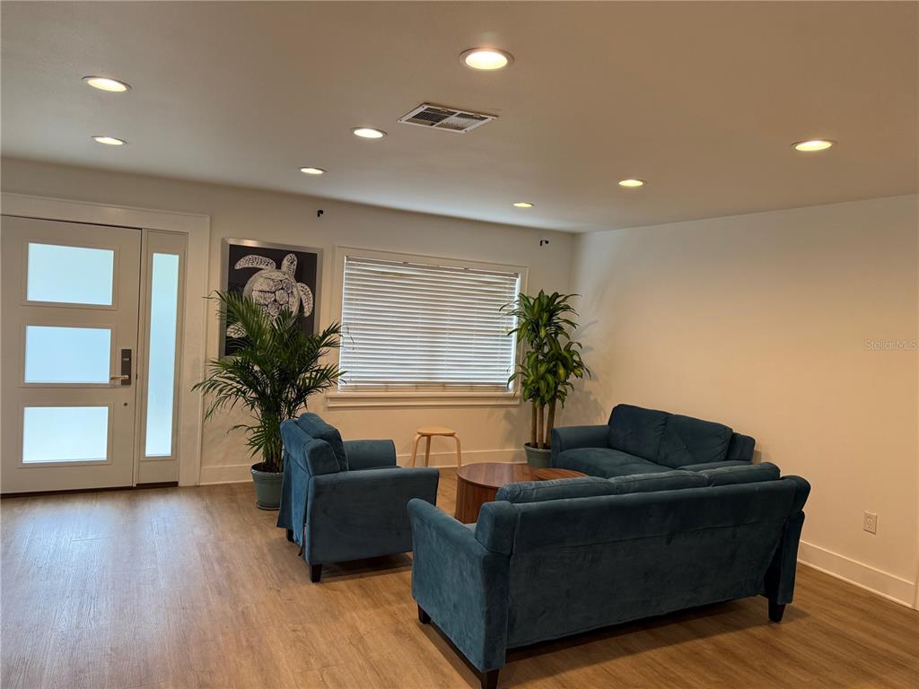 A single-story house with a white exterior and a dark roof sits behind a palm tree — 1243 DINGENS AVENUE, WINDERMERE, FL