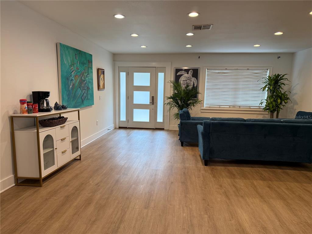 A single-story house with white stucco walls, dark trim, and a gravel driveway — 1243 DINGENS AVENUE, WINDERMERE, FL