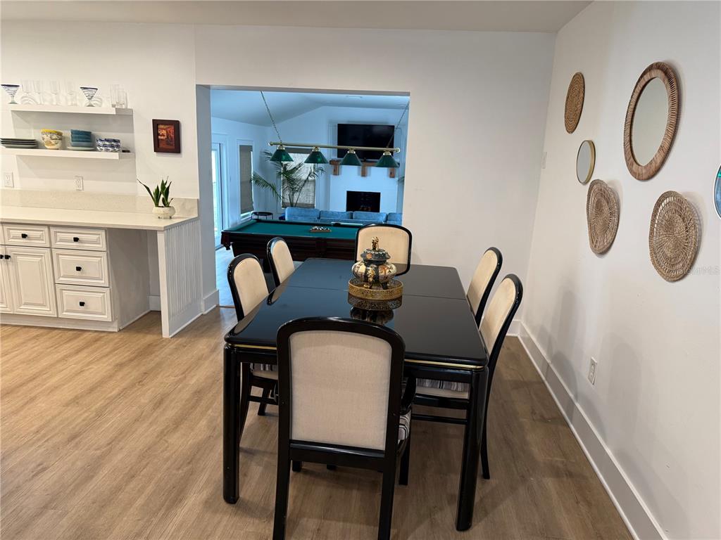 A living room features blue upholstered furniture, a round wooden coffee table, and light flooring — 1243 DINGENS AVENUE, WINDERMERE, FL