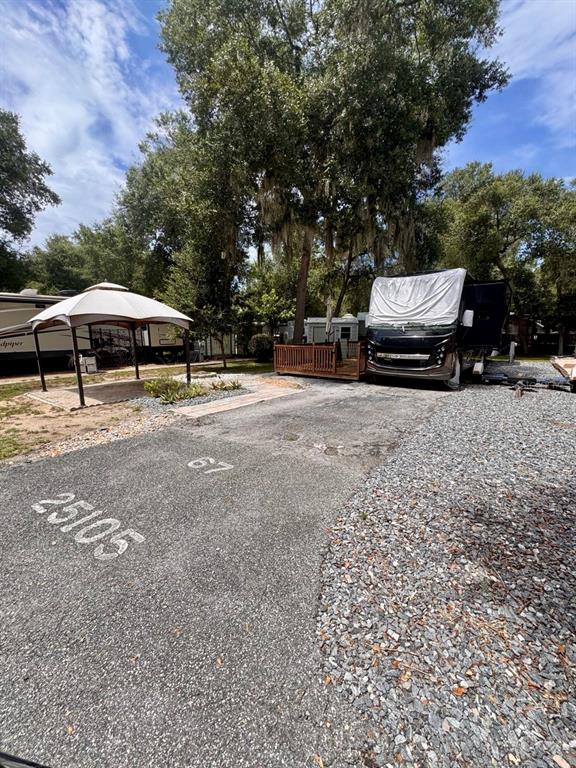 An outdoor RV site features a paved pad, a gazebo, and a parked motorhome — 25105 NE 143RD STREET, SALT SPRINGS, FL