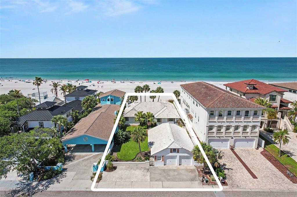 An aerial view of beachfront houses at sunset with a large multi-story home on the right — 18206 SUNSET BOULEVARD, REDINGTON SHORES, FL