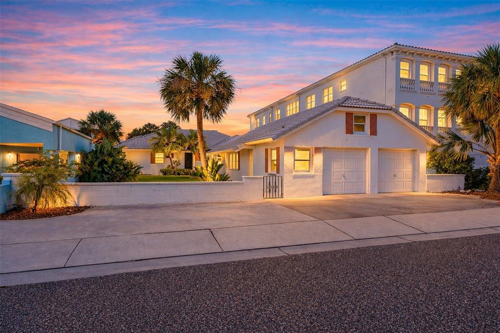 A single-story house with a tiled roof, palm trees, and a walkway at dusk — 18206 SUNSET BOULEVARD, REDINGTON SHORES, FL