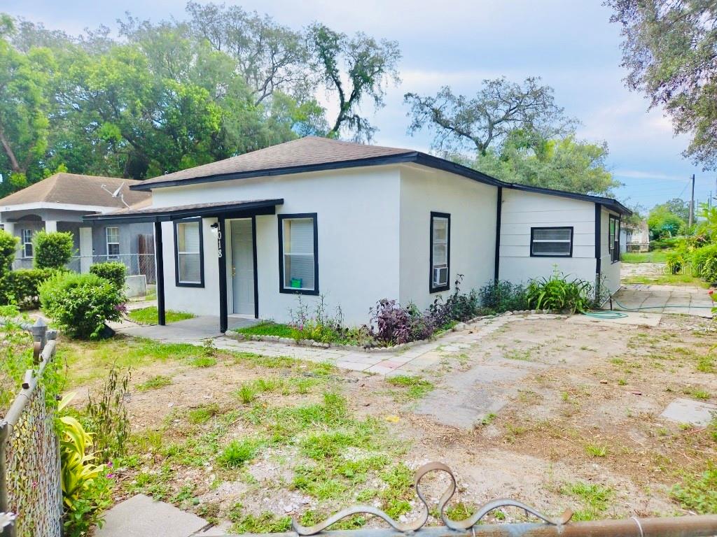 A white single-story house with a flat roof and a small covered front porch — 1018 E HOLLAND AVENUE, TAMPA, FL