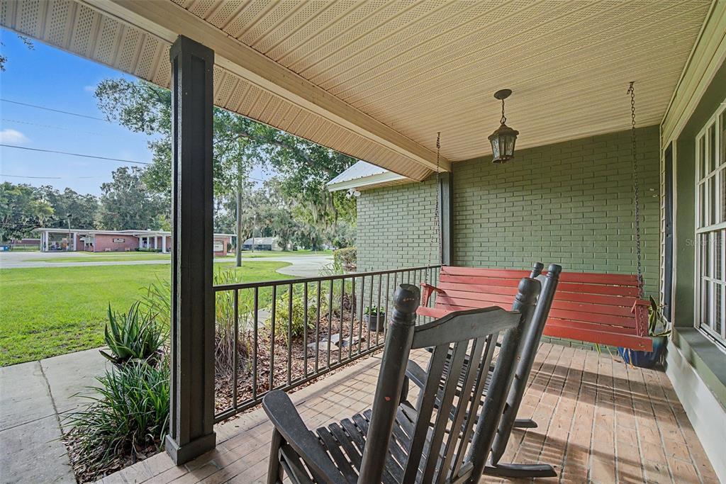 A living room with a large brown leather sectional, tile floors, and two ceiling fans — 510 EDGEWOOD DRIVE, FORT MEADE, FL