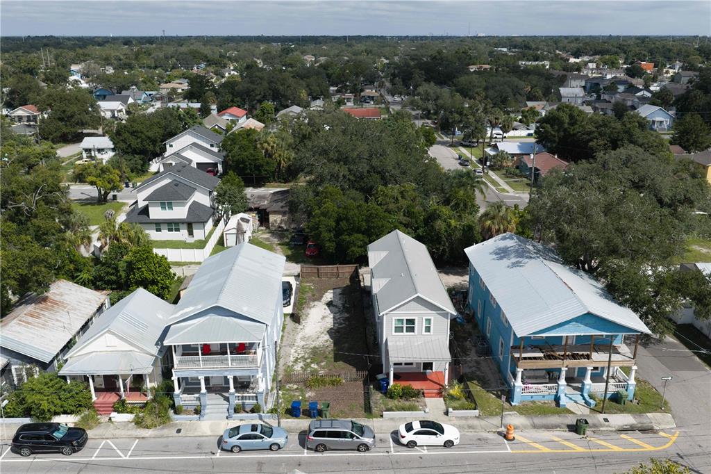 An aerial view shows several houses with metal roofs and a vacant lot in between — 1912 E COLUMBUS DRIVE, TAMPA, FL