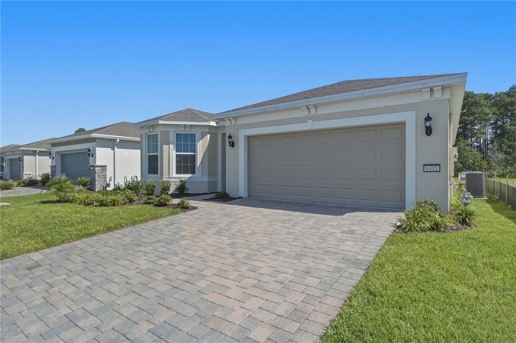 A beige single-story house features a paved driveway, a two-car garage, and a bay window — 6401 WHITE WILLOW COURT, ST CLOUD, FL