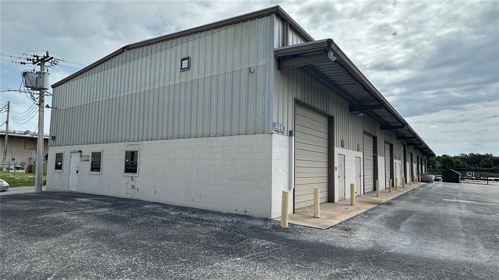 A multi-bay industrial warehouse building features a metal exterior, roll-up doors, and a paved lot — 3120-3126 REYNOLDS ROAD, LAKELAND, FL