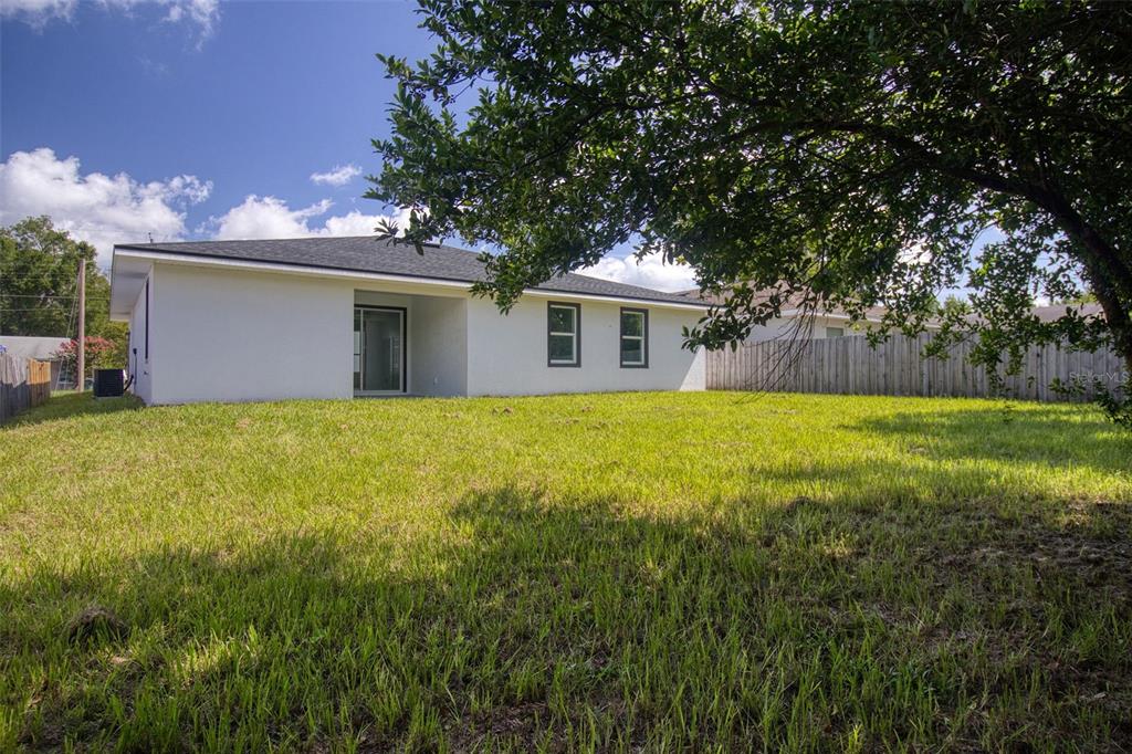 A modern kitchen features a granite-topped island, white cabinetry, and light gray tile flooring — 1246 HERSCHELL STREET, LAKELAND, FL