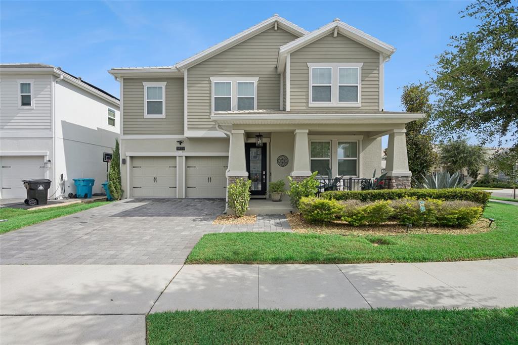 A two-story suburban house with light green siding, a two-car garage, and a front porch — 11479 SATIRE STREET, ORLANDO, FL