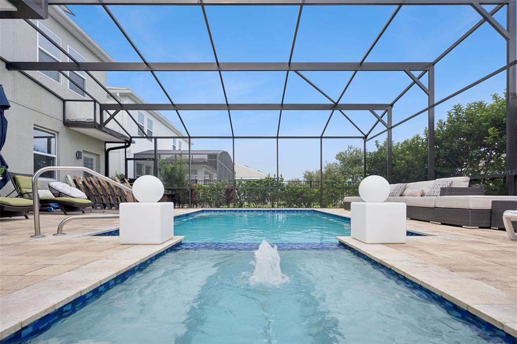 A screened-in swimming pool area features a central fountain, stone decking, and patio furniture — 11479 SATIRE STREET, ORLANDO, FL