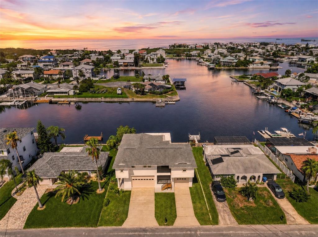 An aerial view shows a waterfront house with a two-car driveway and a backyard dock — 4159 CAMELIA DRIVE, HERNANDO BEACH, FL
