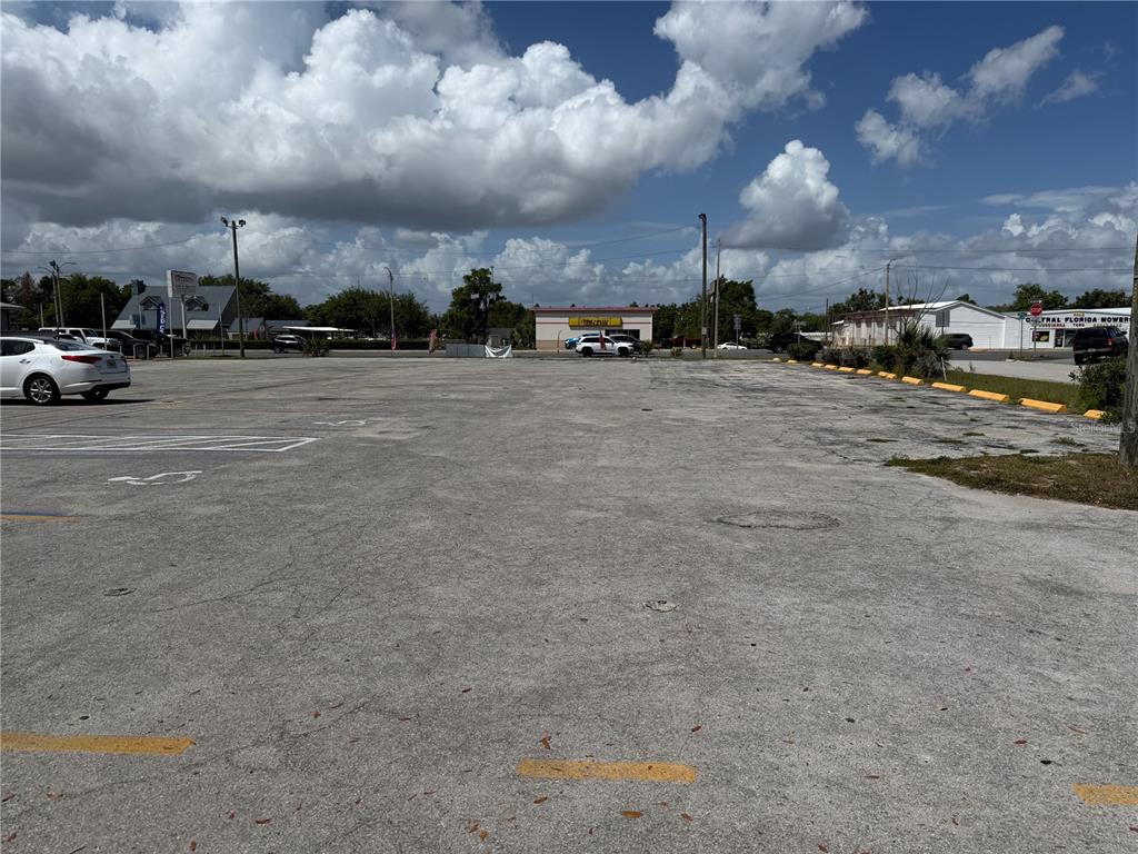 A large, paved parking lot under a bright, cloudy sky — 2001 S BAY STREET, EUSTIS, FL