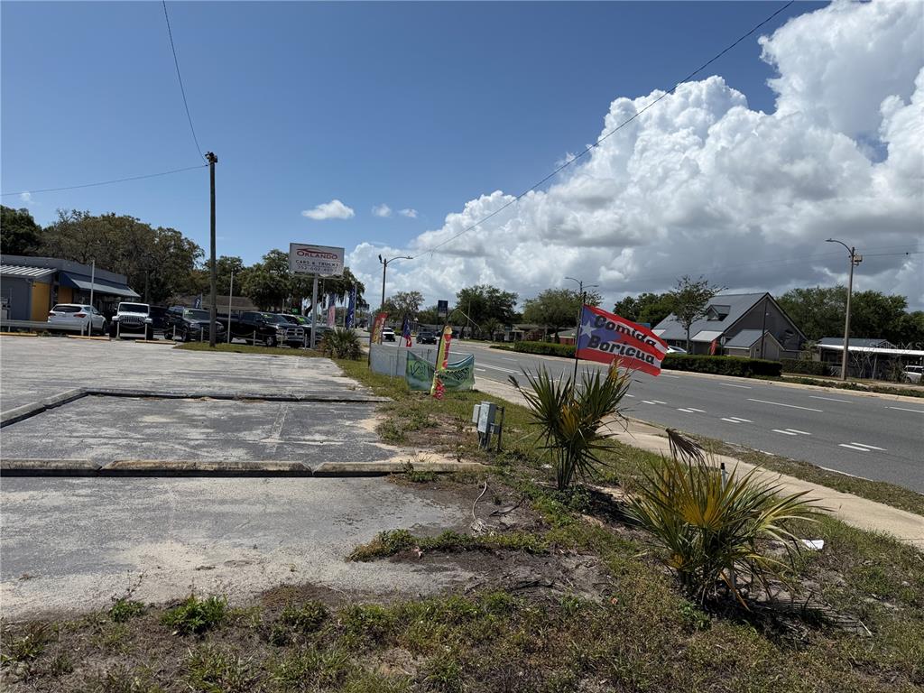 A paved parking lot sits beside a road with a sign advertising Comida Boricua — 2001 S BAY STREET, EUSTIS, FL