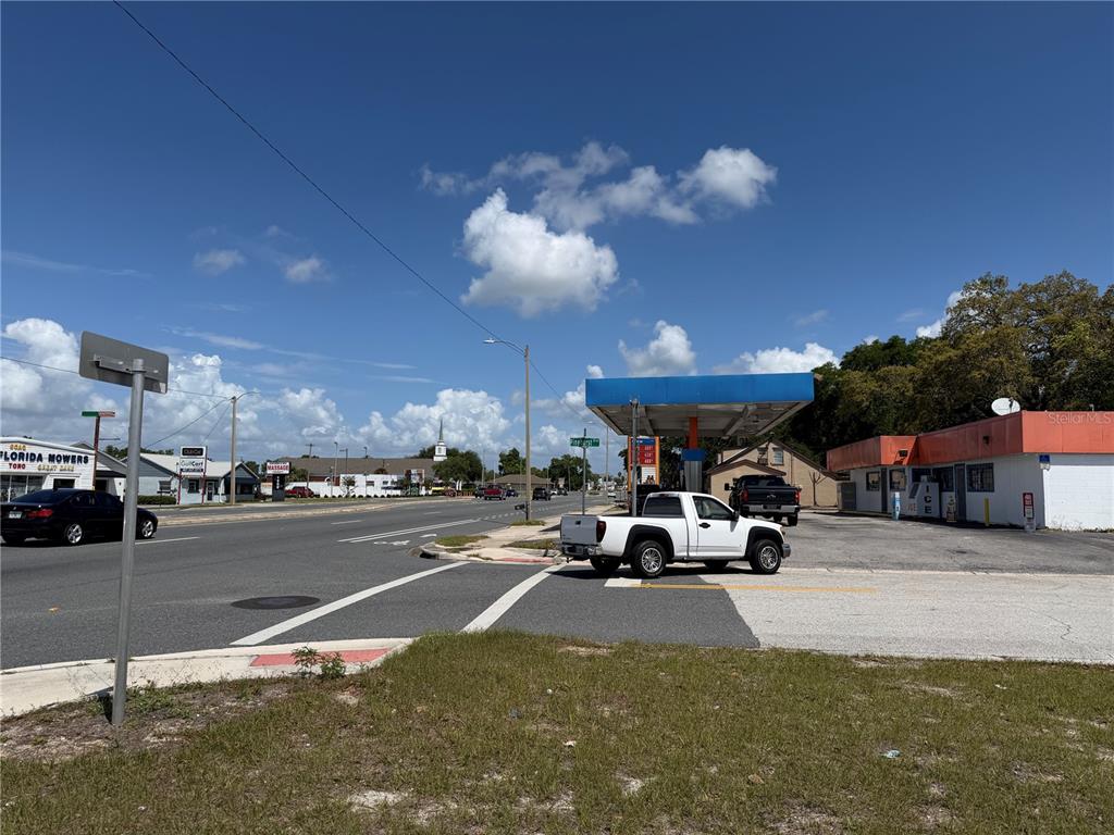 A gas station with a white pickup truck parked under the canopy on a sunny day — 2001 S BAY STREET, EUSTIS, FL