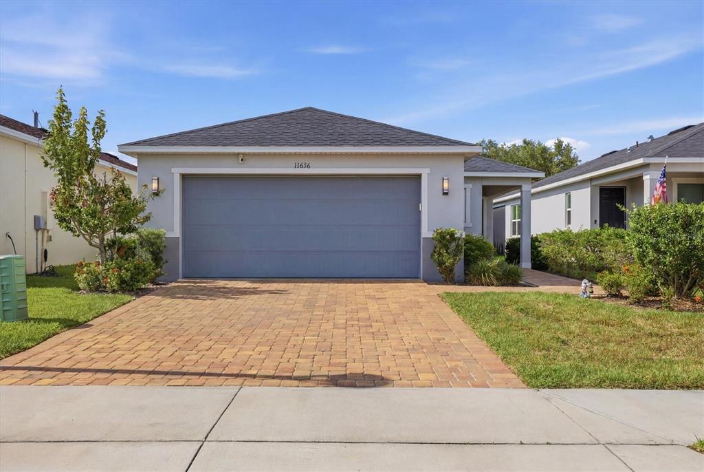 An aerial view shows a suburban neighborhood with houses surrounding a central lake — 11636 LITTLE RIVER WAY, PARRISH, FL