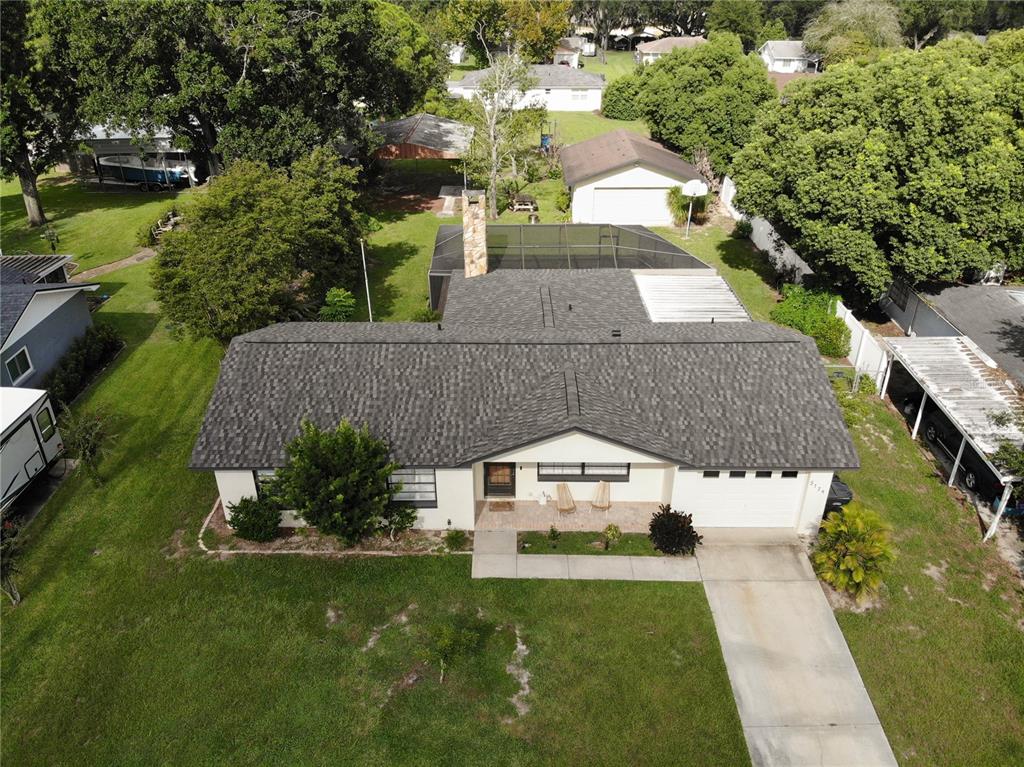 An aerial view of a single-story house with a shingled roof and a screened pool — 5139 IDLEWOOD LANE, LAKELAND, FL