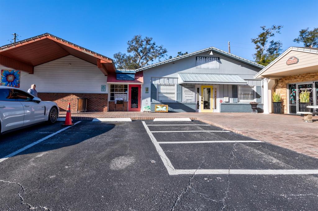 An exterior view of a commercial building with a parking lot and three storefronts — 0 USA, WINDERMERE, FL