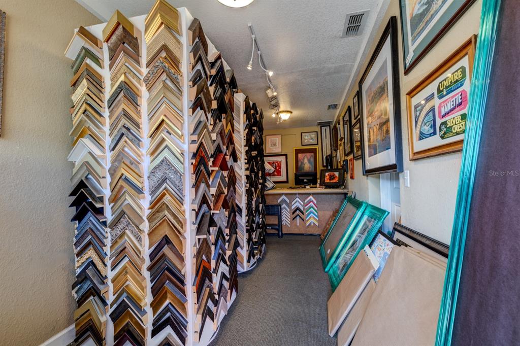 A narrow framing shop features walls lined with numerous frame samples and various framed artwork — 0 USA, WINDERMERE, FL