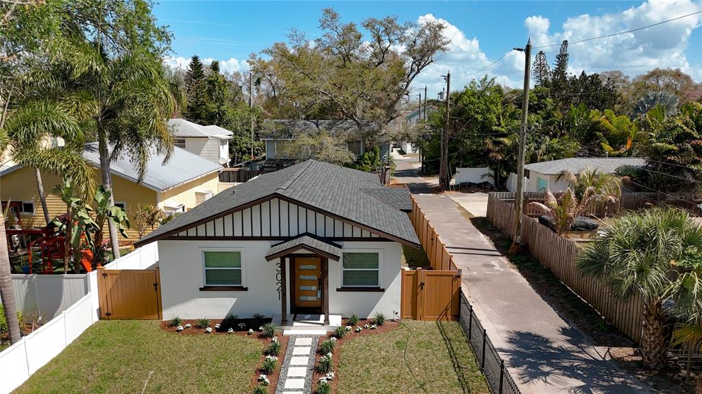 An aerial view shows a white single-story house with a dark roof and wooden gate — 3021 GRANVILLE COURT N, ST PETERSBURG, FL