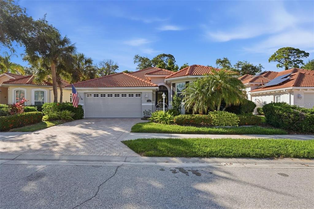 A single-story house with a tiled roof, a two-car garage, and a paved driveway — 5127 HANGING MOSS LANE, SARASOTA, FL