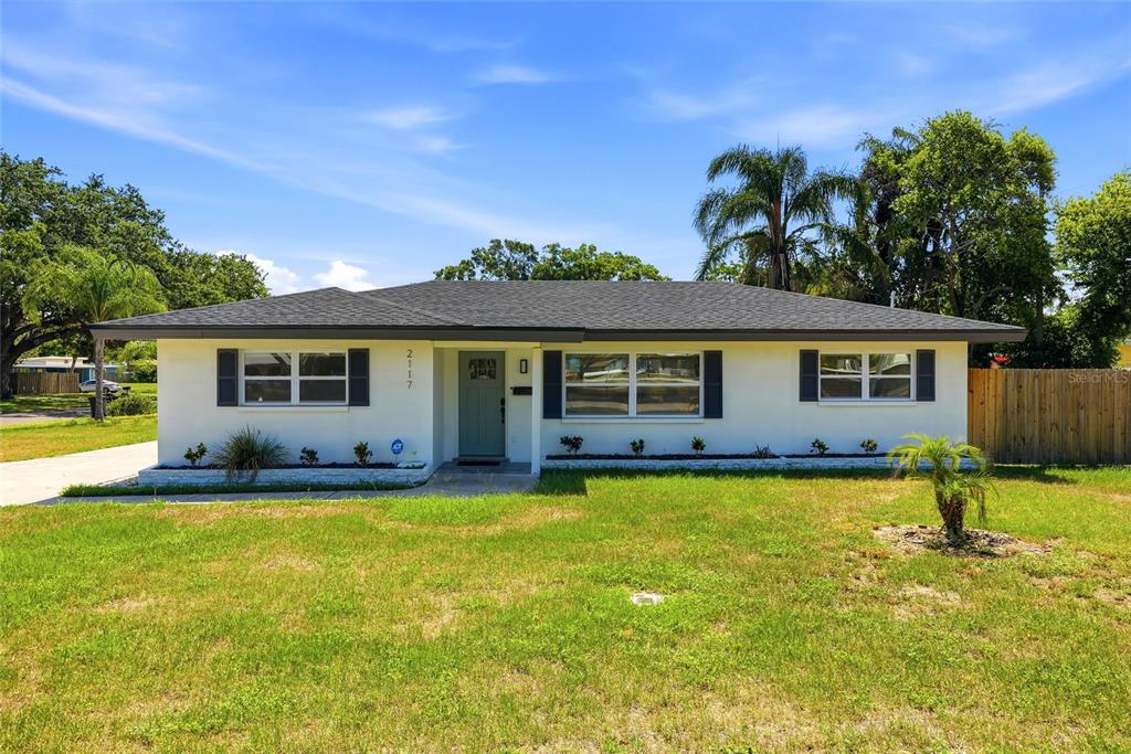 A single-story house with a white exterior, dark shutters, and a dark shingled roof — 2117 N HERCULES AVENUE, CLEARWATER, FL