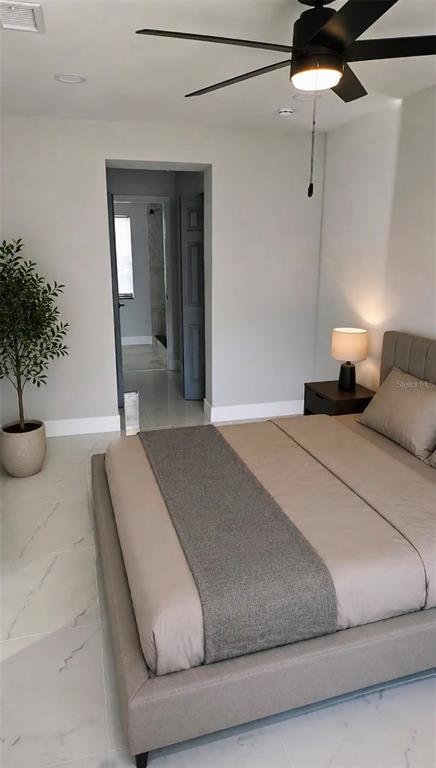A bedroom with a platform bed, ceiling fan, and light-colored tile flooring — 2459 17TH AVENUE S, ST PETERSBURG, FL