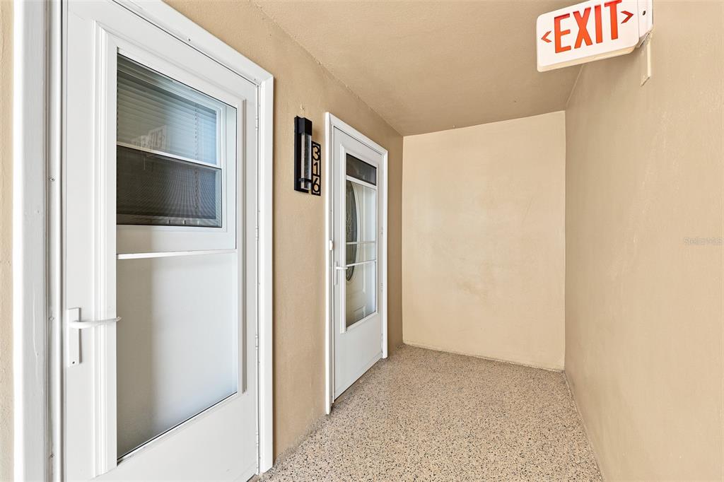 A wooden deck with a bench and a covered grill overlooks a boat dock — 1 BOCA CIEGA POINT BOULEVARD UNIT 316, ST PETERSBURG, FL
