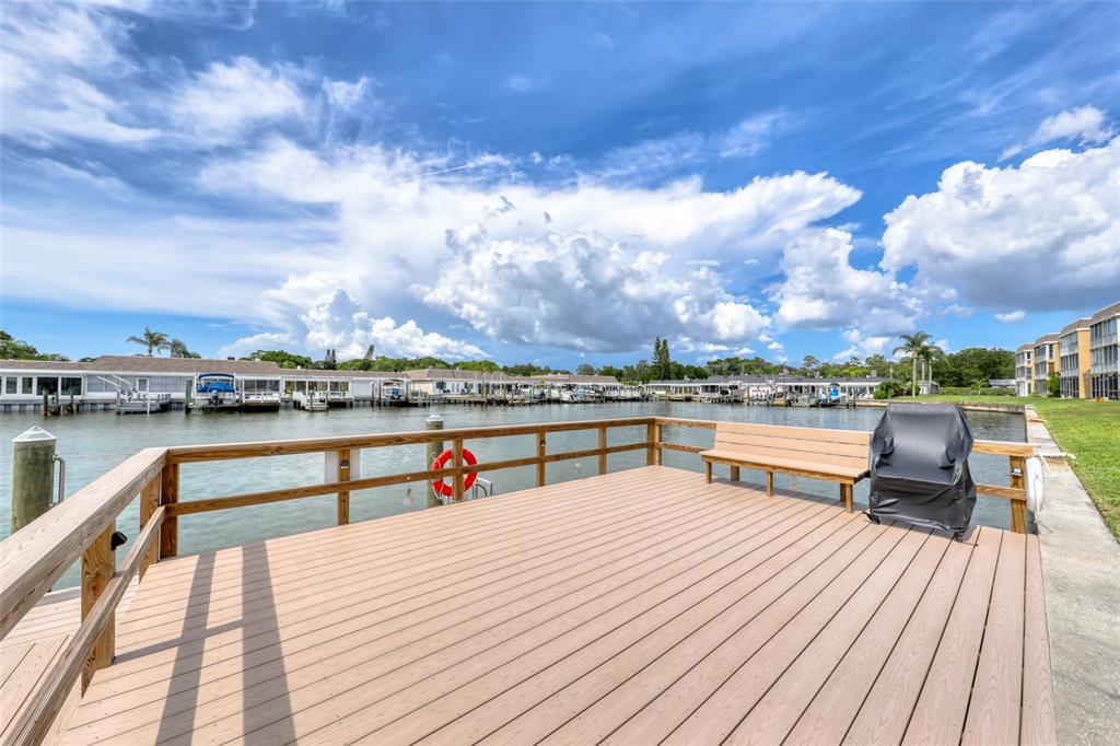 A living room features a beige sofa, patterned armchairs, a glass coffee table, and a balcony — 1 BOCA CIEGA POINT BOULEVARD UNIT 316, ST PETERSBURG, FL