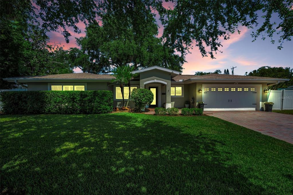 A single-story house with a brick driveway, a two-car garage, and a manicured lawn — 1732 GOLF VIEW DRIVE, BELLEAIR, FL