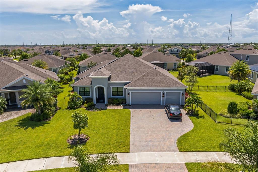 An aerial view of a single-story suburban house with a paved driveway and green lawn — 7356 MILLBROOK AVENUE, MELBOURNE, FL