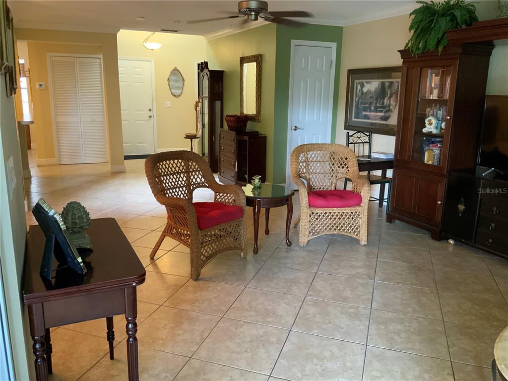 A living room features wicker chairs, tile flooring, and a large wooden display cabinet — 618 MAPLE OAK CIRCLE UNIT 112, ALTAMONTE SPRINGS, FL