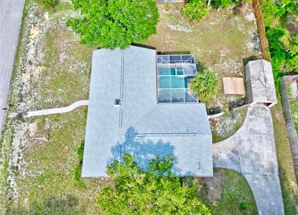 An aerial view of a house with a screened pool, driveway, and detached garage — 2831 ASCOT LANE, DELTONA, FL