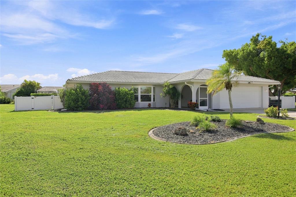 A single-story house with a tiled roof, a two-car garage, and a landscaped front yard — 302 DEGAS DRIVE, NOKOMIS, FL