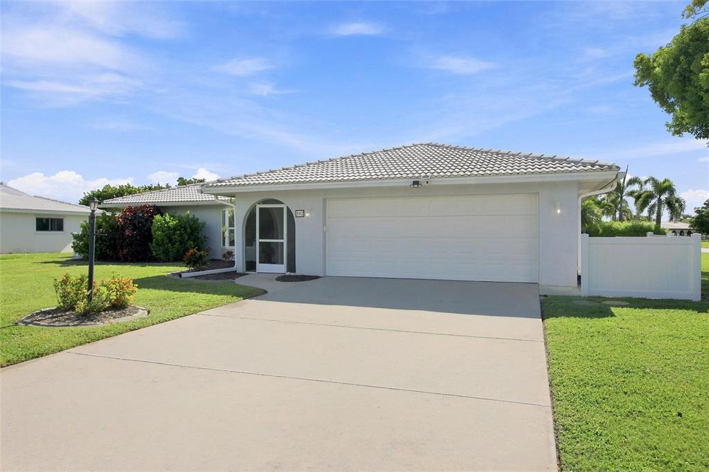 A single-story house with a white garage, arched entryway, and a concrete driveway — 302 DEGAS DRIVE, NOKOMIS, FL