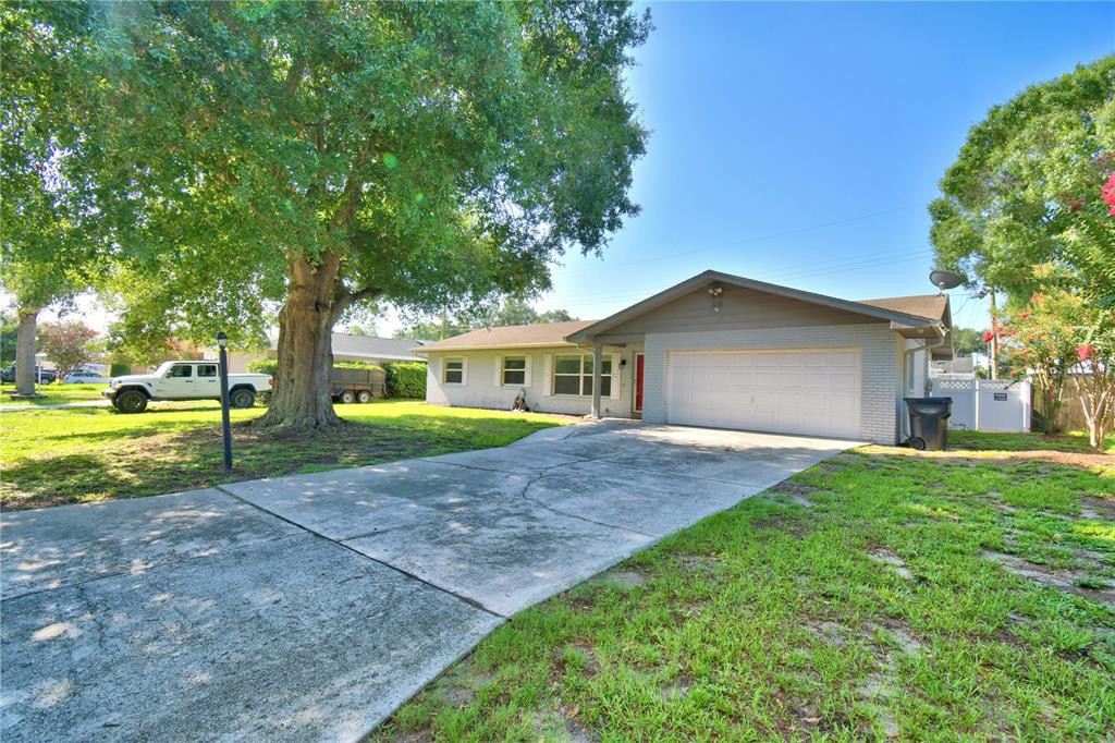 A backyard features a rectangular swimming pool with a concrete deck and a white fence — 153 BROWNING CIR, WINTER HAVEN, FL