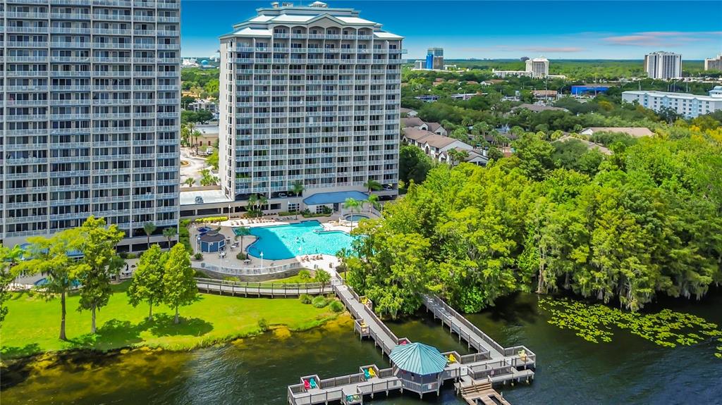 An aerial view of a tall apartment building with a swimming pool and wooden dock — 13427 BLUE HERON BEACH DRIVE UNIT 402, ORLANDO, FL