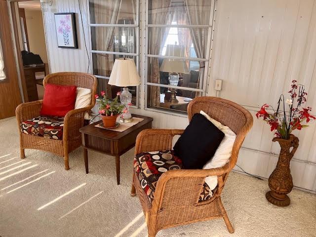 Two wicker chairs sit on a carpeted floor next to a small wooden side table — 3405 LANARK DRIVE, HOLIDAY, FL