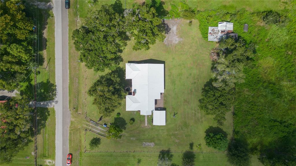 An aerial view shows a house with a white roof situated on a large lot — 2630 KEYSVILLE DRIVE, LITHIA, FL