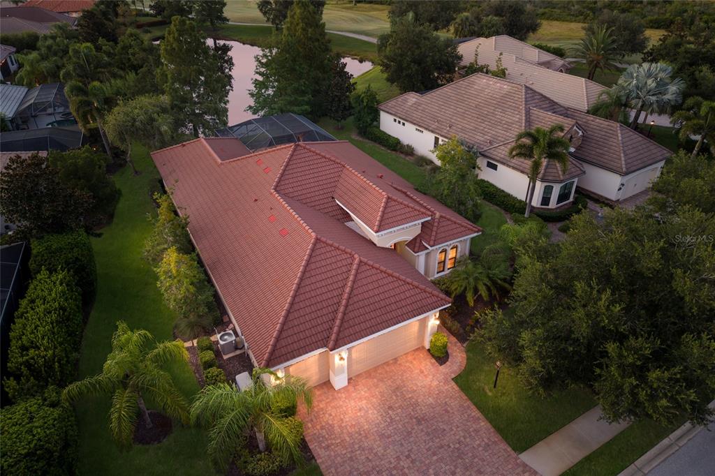 An aerial view of a single-story house with a red tile roof and brick driveway — 15403 HELMSDALE PLACE, LAKEWOOD RANCH, FL